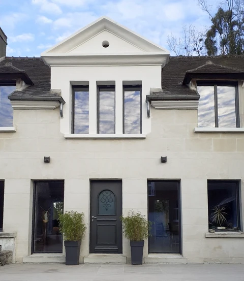 Façade de maison contemporaine rénovée avec extension moderne à toit triangulaire