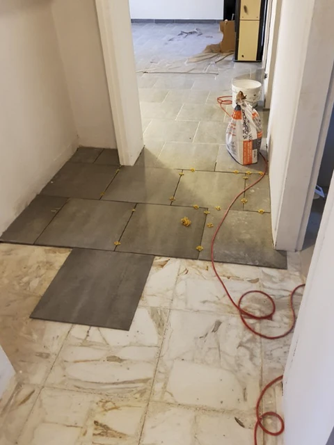 Chantier de rénovation intérieur avec pose de carrelage en cours