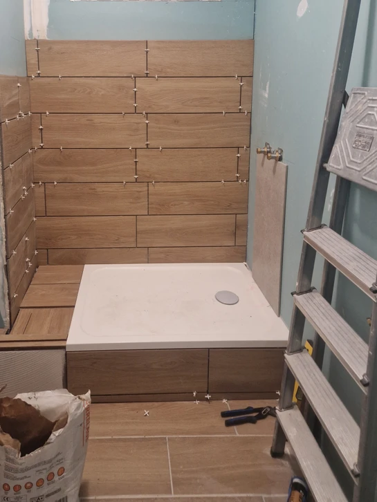 Atelier de menuiserie intérieur avec artisan utilisant une scie circulaire plongeante pour découper une planche de bois massif