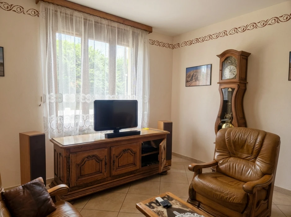 Intérieur résidentiel en cours de rénovation avec échelle de peintre positionnée devant fenêtres à persiennes